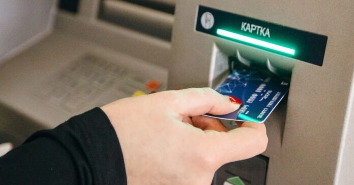 Картка в руці біля банкомату